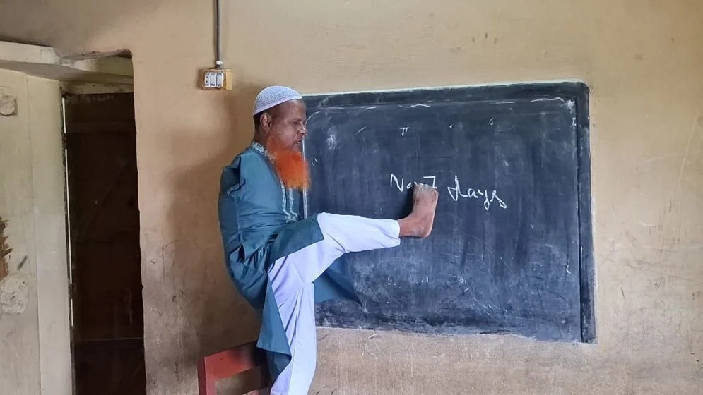 দুই হাত নেই, পা দিয়ে ব্ল্যাকবোর্ডে লিখে ক্লাস নেন শিক্ষক দুঃখু মিয়া